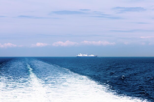 Photo seascape with a white ferry in the distance and waves