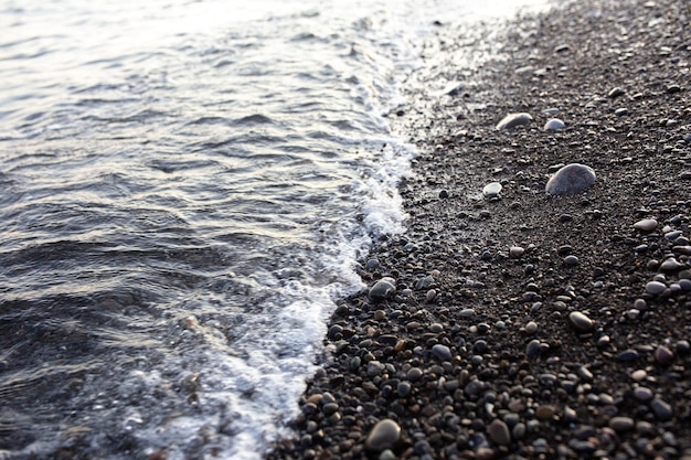 Seashore with pebbles and stones in the evening at sunset