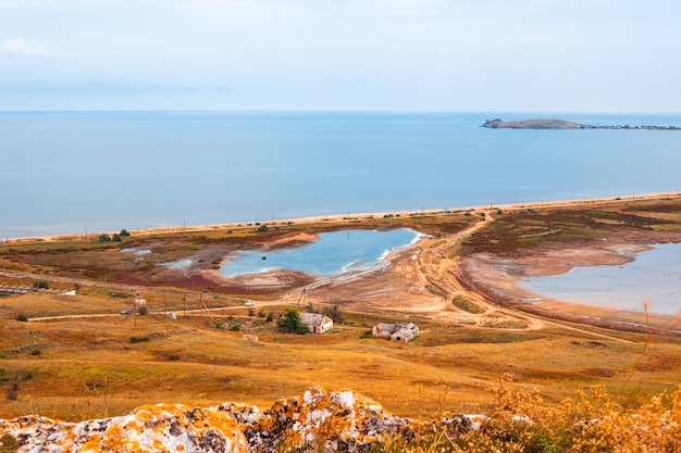 Seashore with a spit and lakes with dried soil Little old houses in the valley Top view of the natural landscape