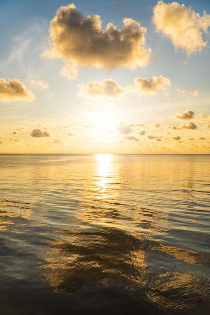 Seaside view reflection sunset sky vertical in the evening with colorful orange bright sunlight