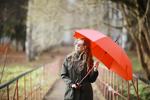 seasonal autumn portrait, sad girl with umbrella, november seasonal virus immunity on a walk