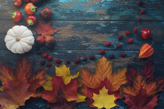 Seasonal composition with pumpkin and autumn leaves on rustic wooden table with space for text halloween or thanksgiving decoration background top view