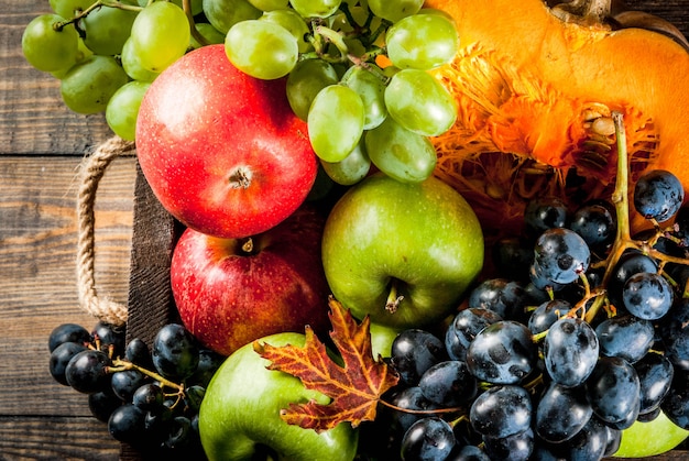 Seasonal fall fruits and pumpkin on wooden table