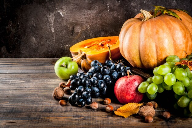 Seasonal fall fruits and pumpkin on wooden table