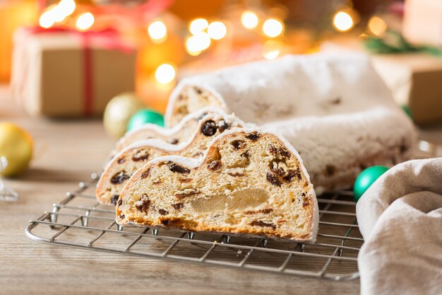 Seasonal food and drink, winter concept. Traditional European German homemade Christmas cake, pastry dessert Stollen on a wooden backgrounds with festive decoration.