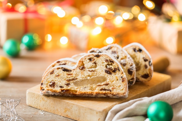 Seasonal food and drink, winter concept. Traditional European German homemade Christmas cake, pastry dessert Stollen on a wooden backgrounds with festive decoration.