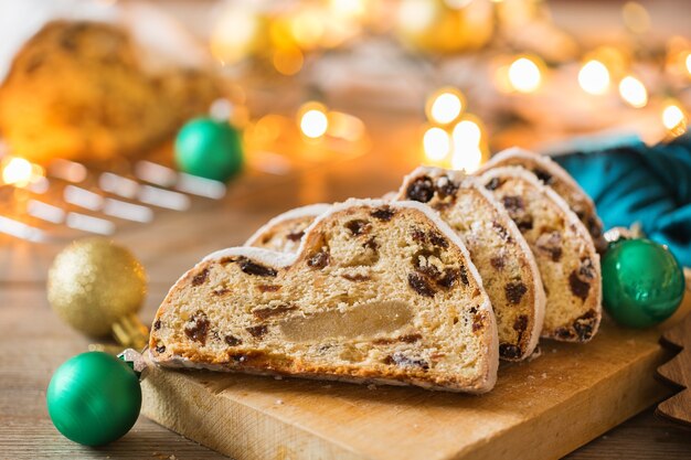 Seasonal food and drink, winter concept. Traditional European German homemade Christmas cake, pastry dessert Stollen on a wooden backgrounds with festive decoration.