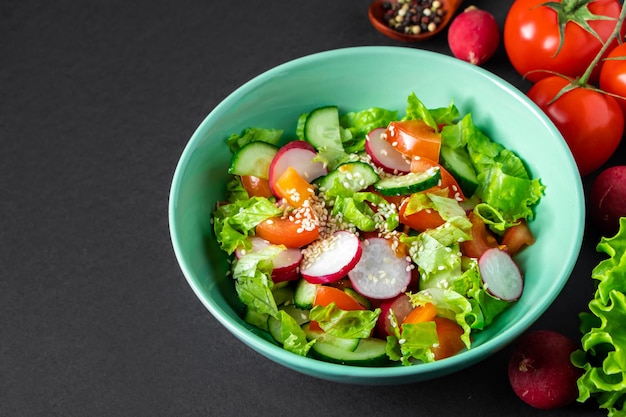 Seasonal vegetable salad from organic farm products on gray background Mix of tomatoes cucumbers