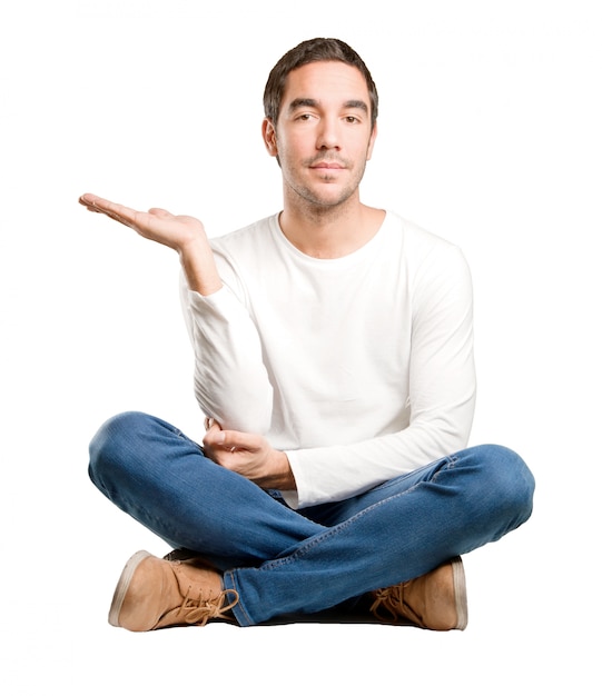 Seated young man with show gesture