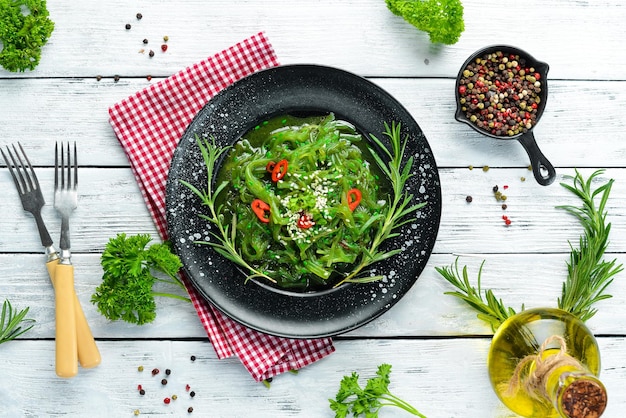 Photo seaweed salad on a black stone plate chinese cuisine top view free copy space