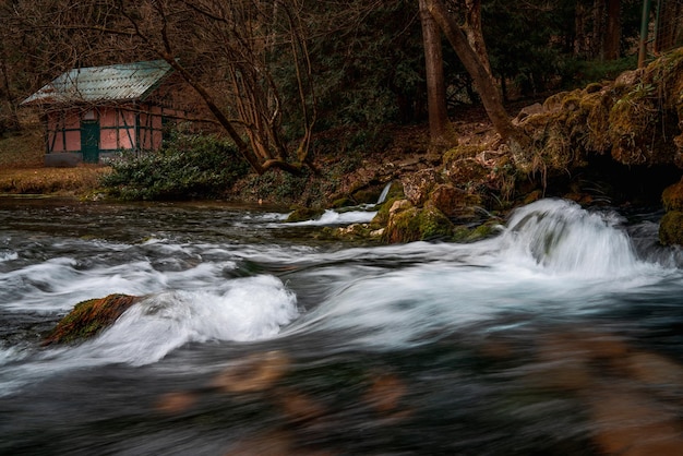 Secluded cabin in winter landscape Water stream Long exposure shot