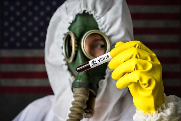 Secret lab scientist in protective suit and gas mask holds test tube