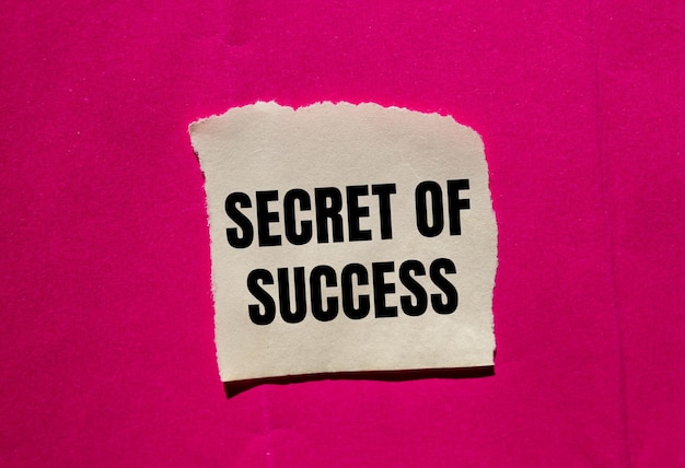 Photo secret of success message written on ripped torn paper piece on pink background conceptual secret of success symbol copy space