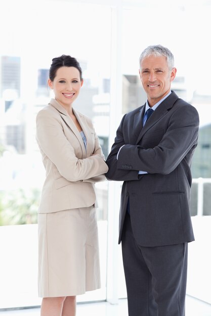 Secretary and her director showing smiling in front of the window