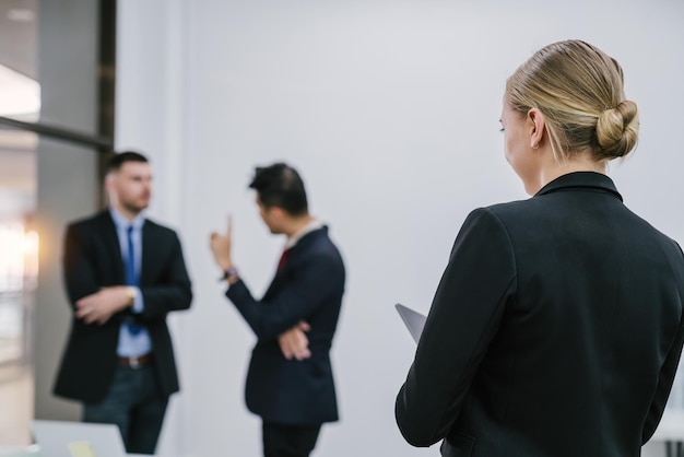 A secretary woman is writing on a computer tablet while standing in the meeting room Female secretary meeting recording concept