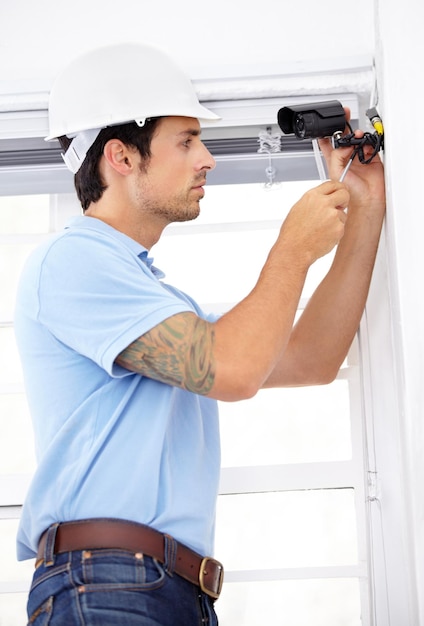 Securing your home as if it were his own Shot of a handsome young man installing a security camera