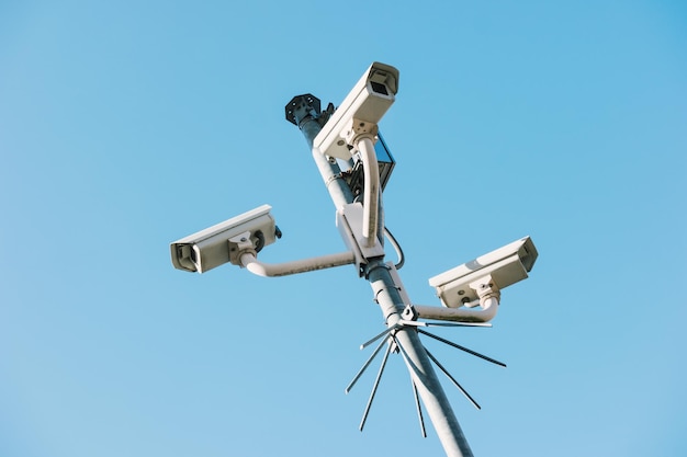 Security cctv surveillance cameras in front of blue sky concept for counterterrorism protesters antiterrorism and protection from crime