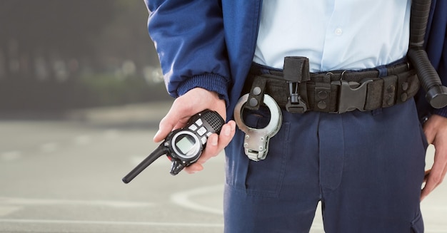 Security guard lower body with walkie talkie against blurry street