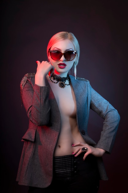 Seductive woman with decollete wearing glasses and dressed in jacket