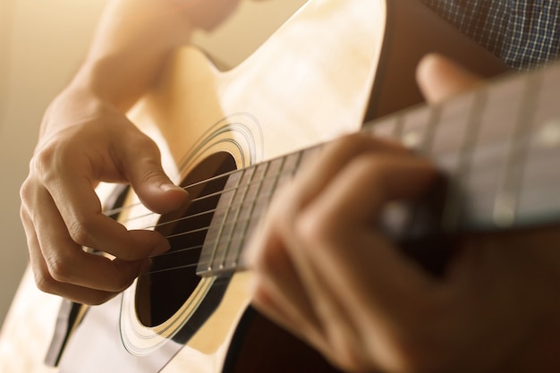 Select focus and soft focus , Man's hand playing acoustic guitar , musical concept