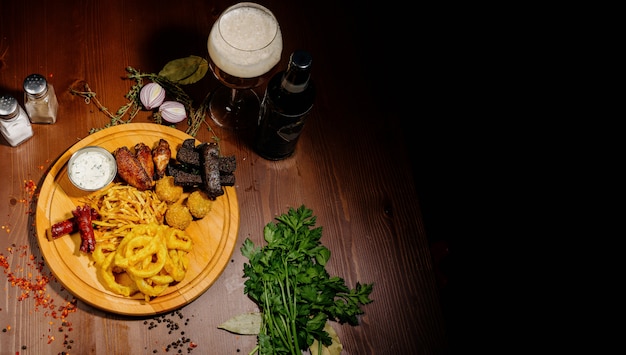 Selection of beer and snacks. Chips, fish, beer sausages on the table