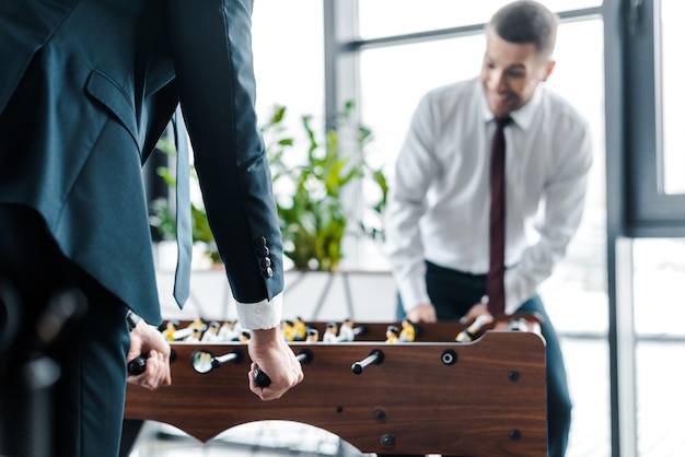 Selective focus of businessmen playing table football in modern office