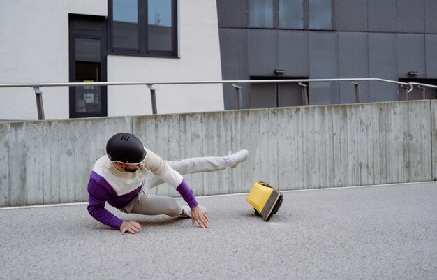 Selective focus caucasian man fallen on the asphalt ground while driving at electronic board High quality photo