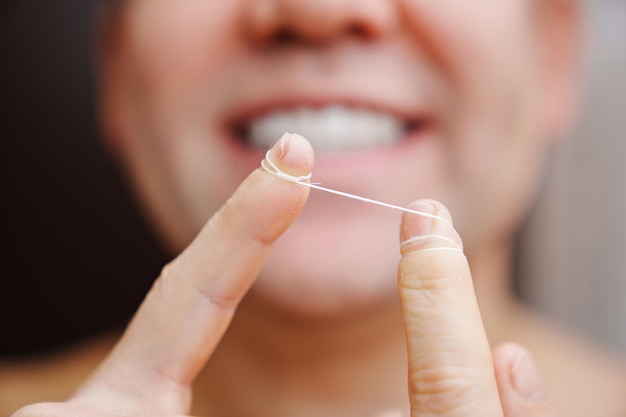 Selective focus closeup a man brush your teeth with dental floss