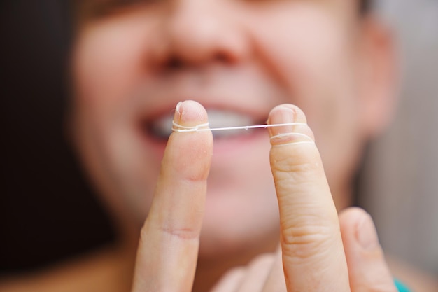 Selective focus closeup a man brush your teeth with dental floss