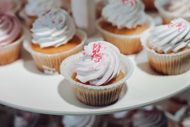 Photo selective focus of cute delicious cupcakes served on plate