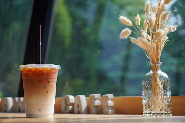 Selective focus Fresh coffee iced cappuccino Macchiato latte with two tones layer separate milk and coffee cold Iced black coffee mixed with milk in plastic glass on wooden table in cafe