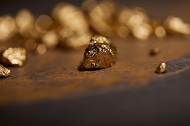 Selective focus of golden stones on grey and brown marble surface with blurred background