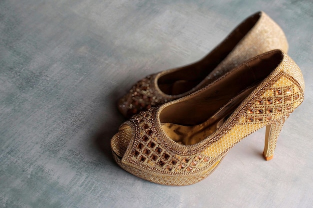 Selective focus image of women sparkly high heels on concrete floor