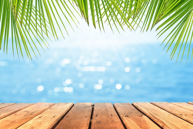 Selective focus of old wood table with beautiful beach background for display your product.