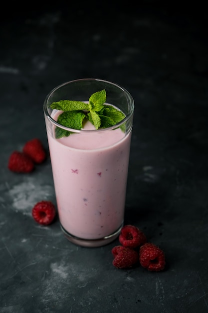 selective focus, proper nutrition, fresh berry yogurt with fresh raspberries, in a dark key