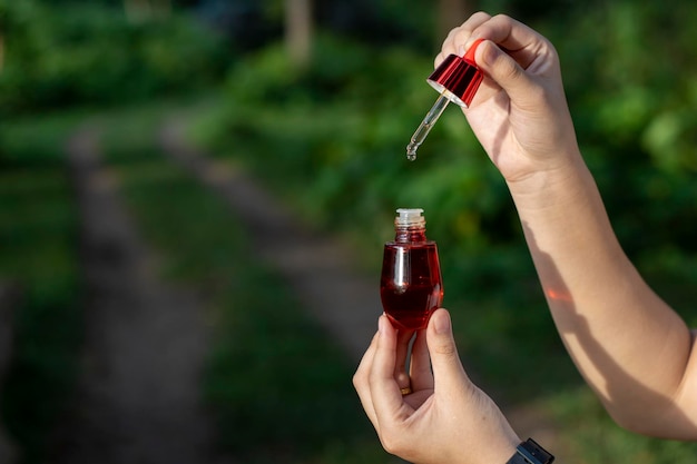 Selective focus red facial serum bottle in asian womans hand