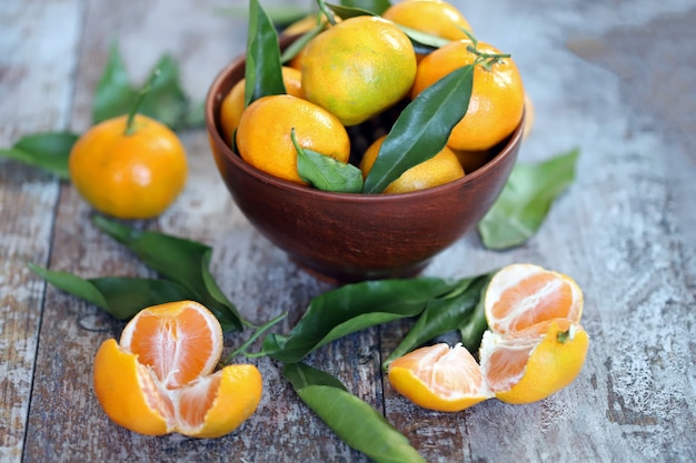 Selective focus. Ripe juicy tangerines in a bowl. Tangerine leaves. Fresh fragrant mandarins. Harvest tangerines.