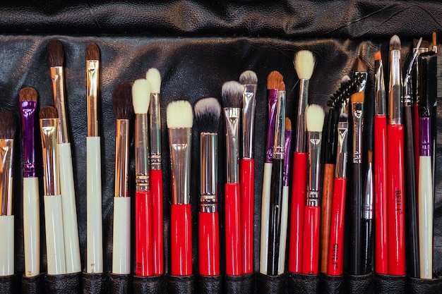 Selective focus Set of makeup stylist brushes Different makeup brushes in black leather case