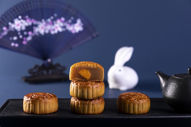 Photo selective focus shot of delicious traditional chinese mooncakes and a teapot