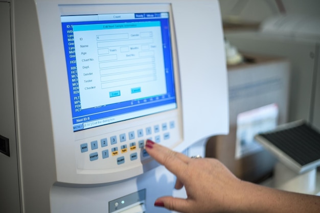 Selective focus shot of a female doctor adjusting the CBC complete blood count blood test machine