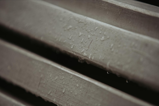 Photo selective focus shot of a wooden bench with rain drops