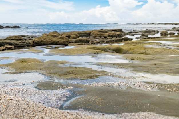 Selective focus of stones and sand on the seashore in daylight