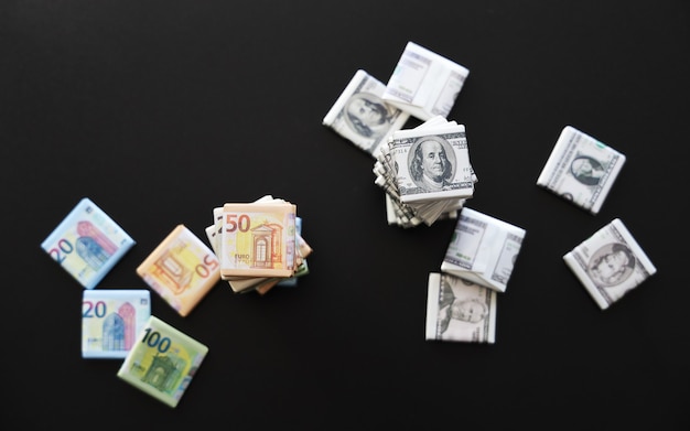 Selective focus on top of stack of wrapper with euro and dollars signs