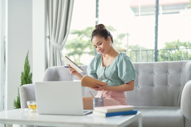 Self Education At Home. Concentrated mature woman writing in notebook