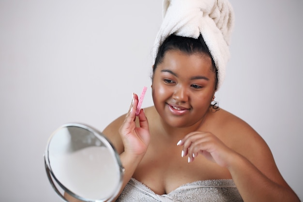 Self-help. Beautiful african american woman in bathrobe ready to apply makeup,