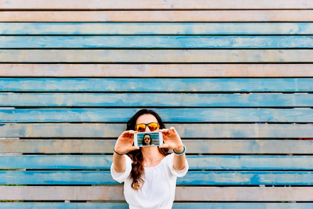 Self portrait of beautiful young woman with mobile. Selfie Concept.