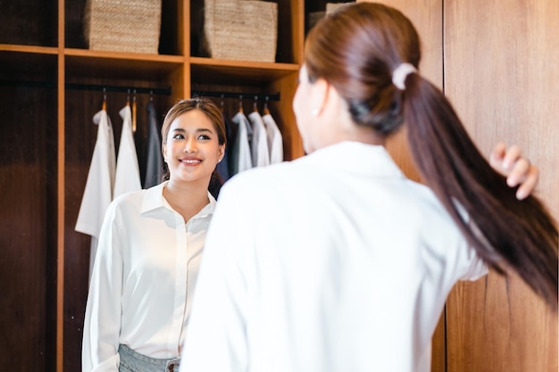 Photo selfconfidence young beautiful asian woman happily dressed in front of the mirror