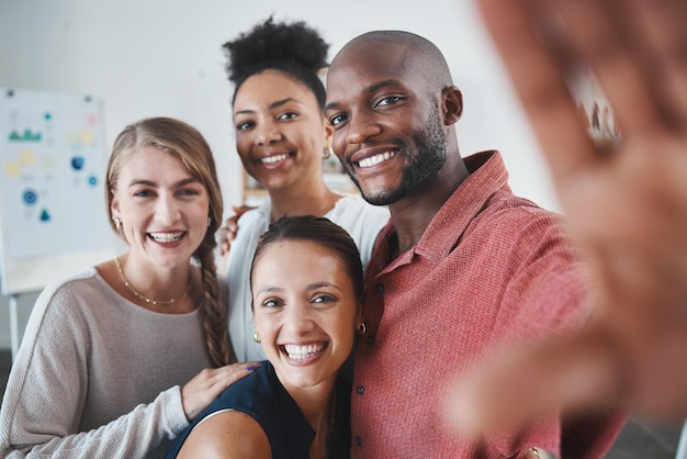 Selfie friends and teamwork with a black man and team taking a photograph together in a work office Collaboration success and business with a male and female employee group posing for a picture