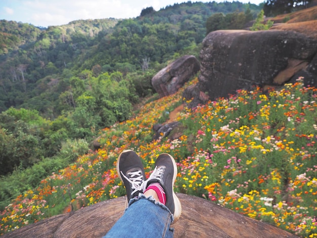 Selfie hipster wearing black sneaker shoes over wild flower field background