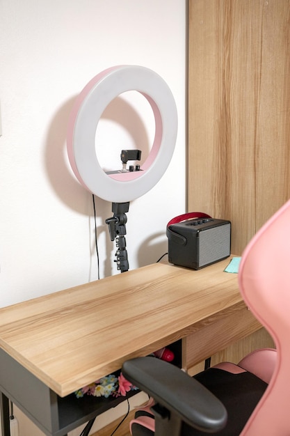 Selfie LED light with wooden table gaming chair and speaker in room